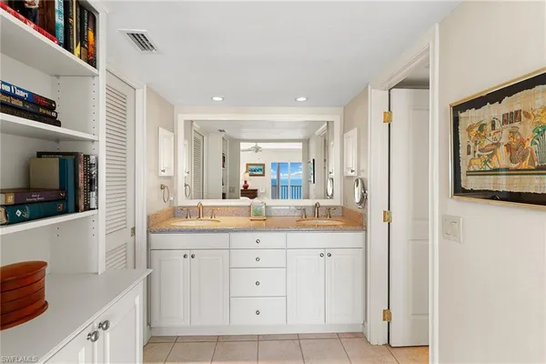 a hall with kitchen island a sink a stove and cabinets