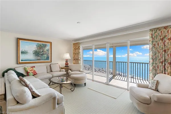 a living room with furniture and a large window with balcony view
