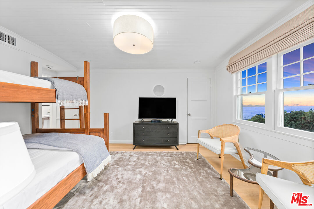 31202 Broad Beach Road Malibu, CA 90265 - Photo 24 of 38 a bedroom with a bed and a chandelier