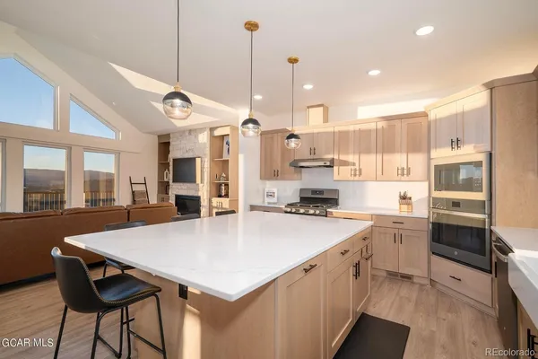 a kitchen with a stove a refrigerator a sink dishwasher with a dining table and chairs