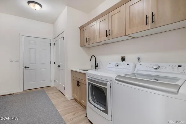 a utility room with sink dryer and washer