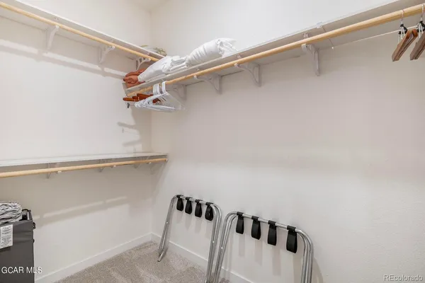 a view of walk in closet with empty racks