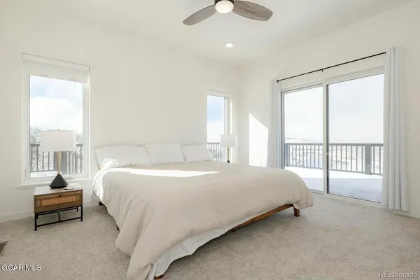 a bedroom with a bed and a large window