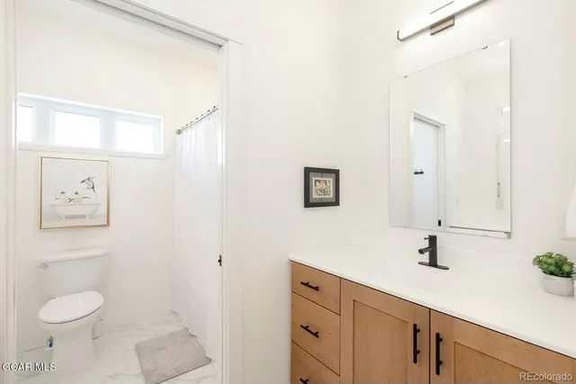 a bathroom with a toilet sink and mirror