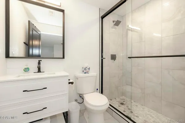 a bathroom with a sink a toilet and shower
