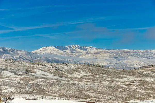 a view of a wooden floor and mountain in the background