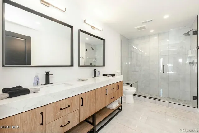 a bathroom with a double vanity sink mirror double and shower