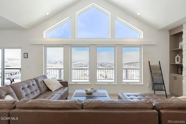 a living room with furniture and two window