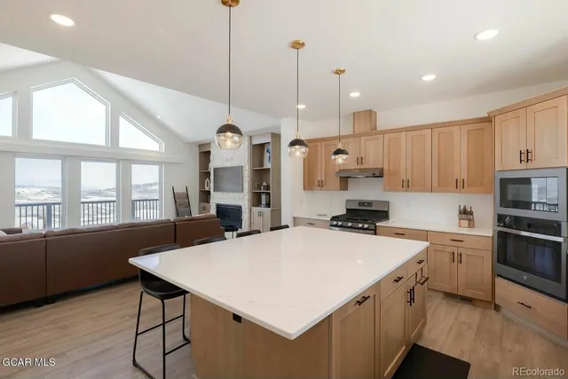 a kitchen with a stove a refrigerator a sink dishwasher with a dining table and chairs