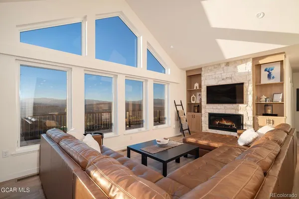 a living room with furniture a flat screen tv and a fireplace