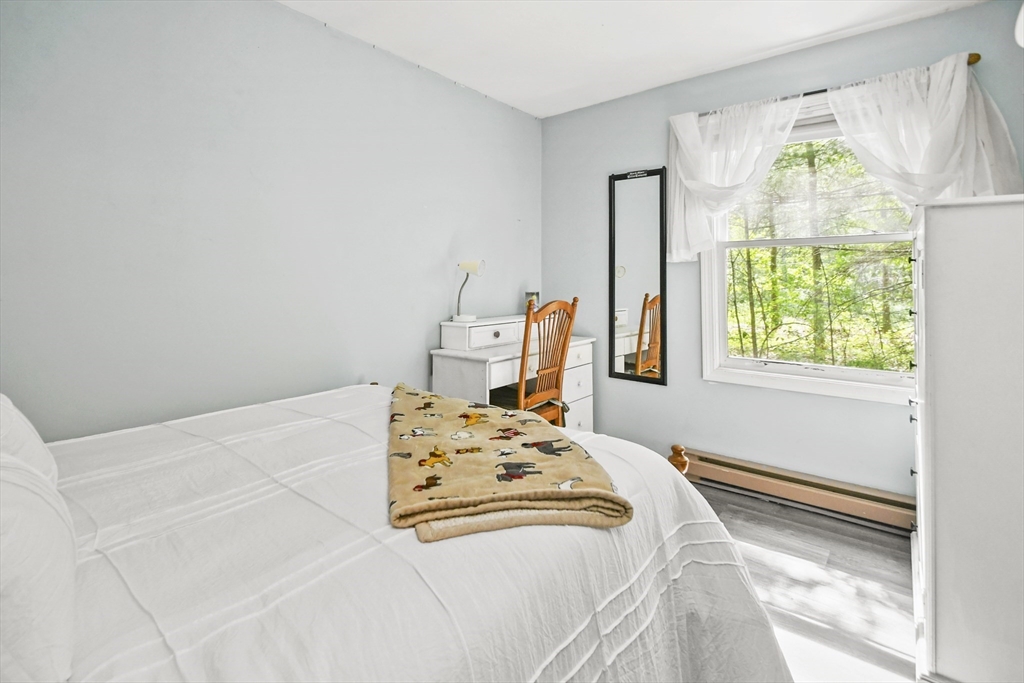 231 Georgetown Road Boxford, MA 01921 - Photo 15 of 28 a bedroom with a bed next to a window and a wooden floor