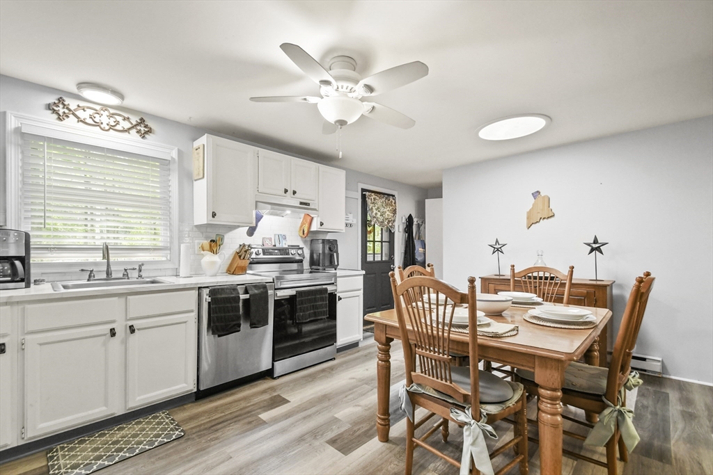 231 Georgetown Road Boxford, MA 01921 - Photo 7 of 28 a kitchen with a dining table chairs and white cabinets
