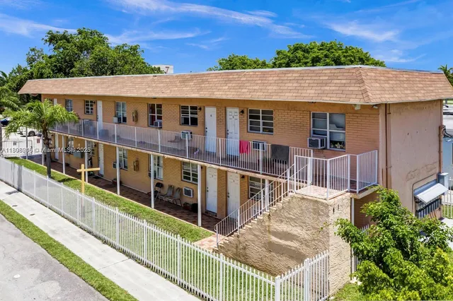 aerial view of a house with large windows and a small yard