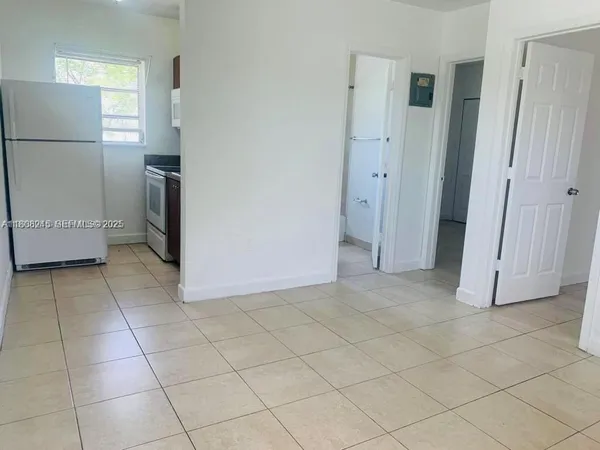 a view of a kitchen with a refrigerator and a stove top oven