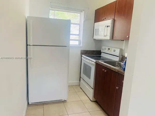 a kitchen with a refrigerator sink stove and cabinets