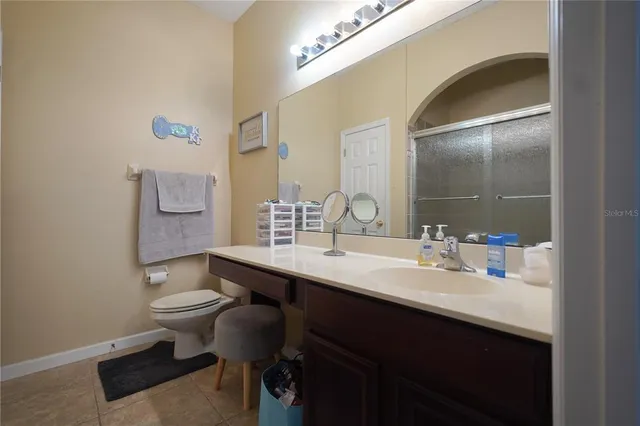a bathroom with a sink a toilet a mirror and vanity