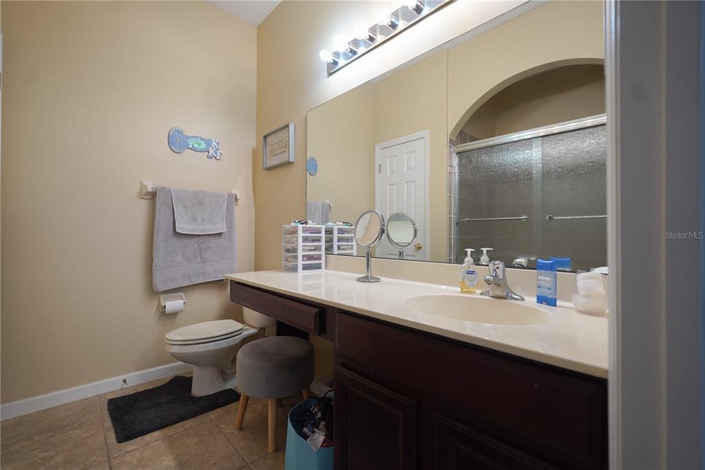 16307 Old Ash Loop Orlando, FL 32828 - Photo 12 of 26 a bathroom with a sink a toilet a mirror and vanity