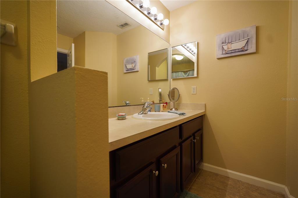 16307 Old Ash Loop Orlando, FL 32828 - Photo 21 of 26 a bathroom with a sink and a mirror