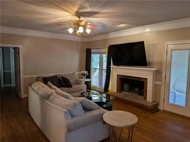 a living room with furniture a fireplace and a flat screen tv