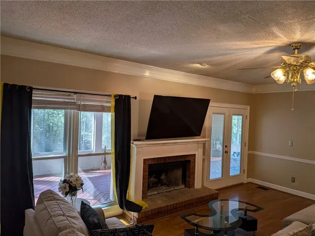 a living room with furniture a flat screen tv and a fireplace