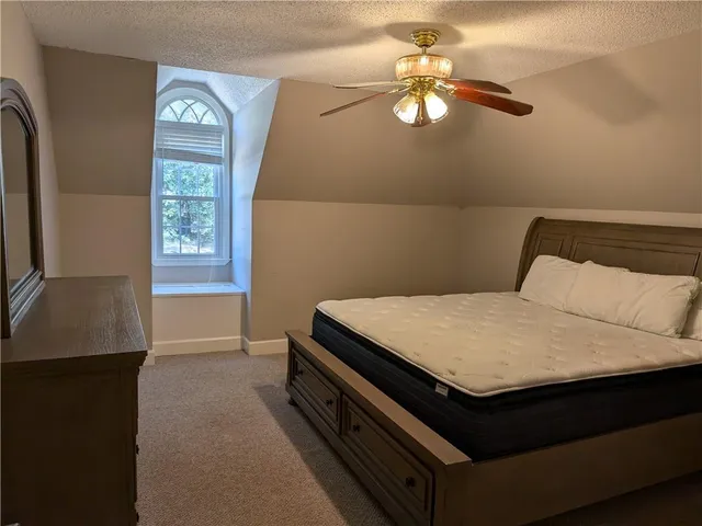 a bed sitting in a bedroom next to a window