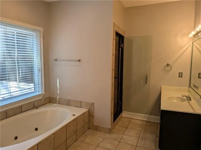 a bathroom with a tub sink and mirror