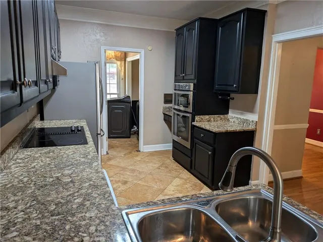 a kitchen with a refrigerator sink and wooden floor