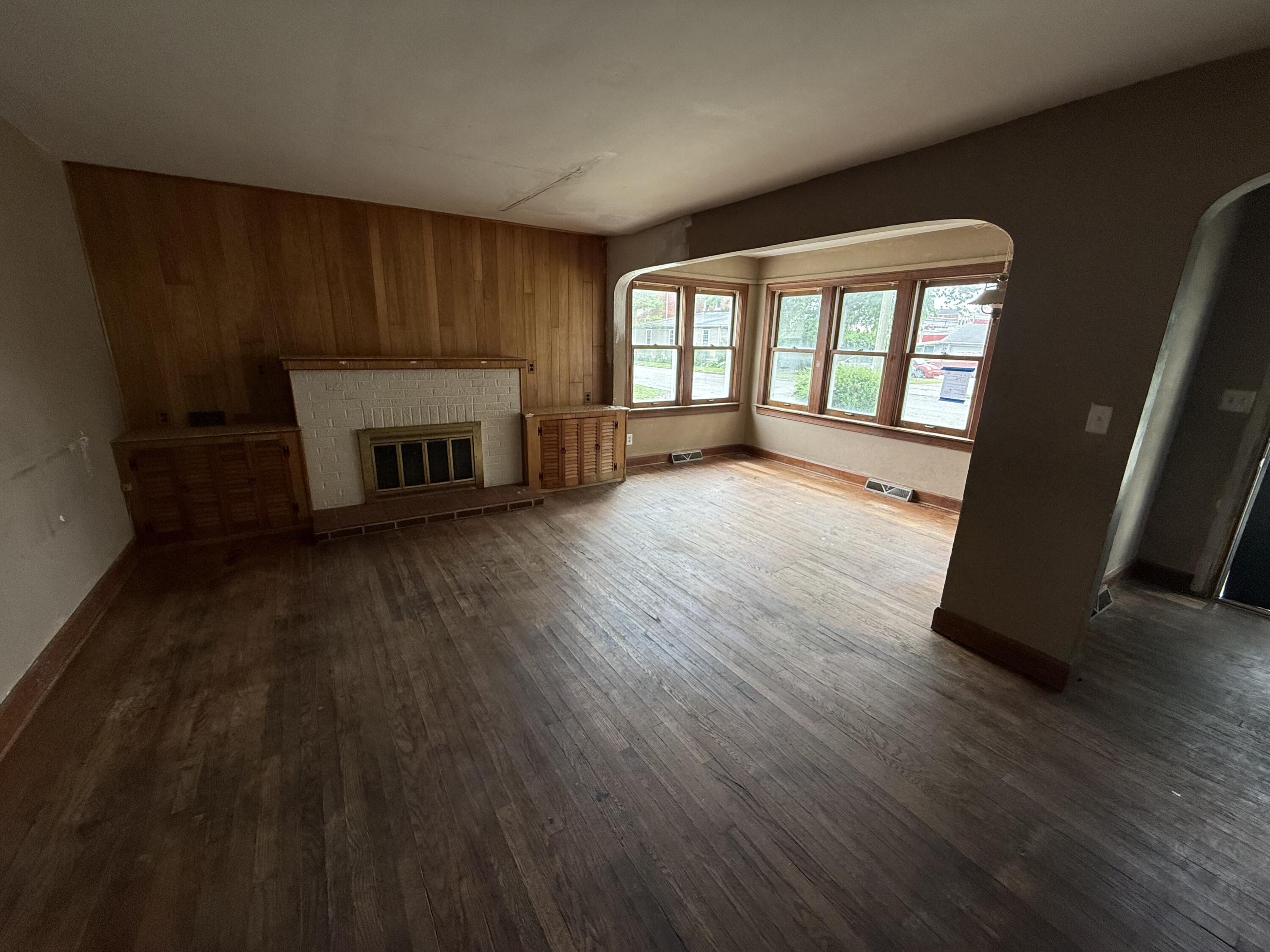 118 West Spring Street Winamac, IN 46996 - Photo 2 of 11 a view of an empty room with a fireplace and wooden floor