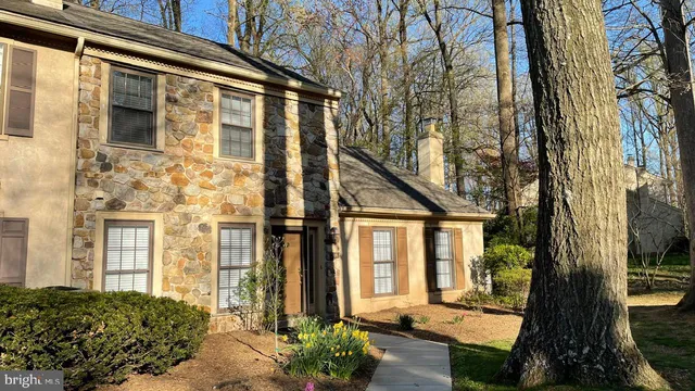 a view of a brick house with a large windows and a large tree