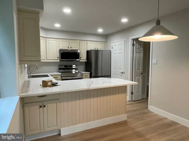 a kitchen with stainless steel appliances a stove refrigerator and microwave