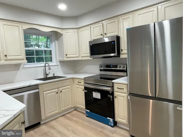 a kitchen with stainless steel appliances a refrigerator sink and microwave