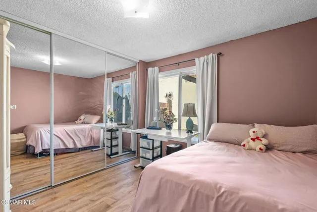 a bedroom with a bed and large window with balcony view