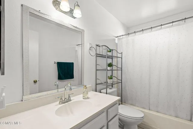 a bathroom with a sink toilet mirror and shower