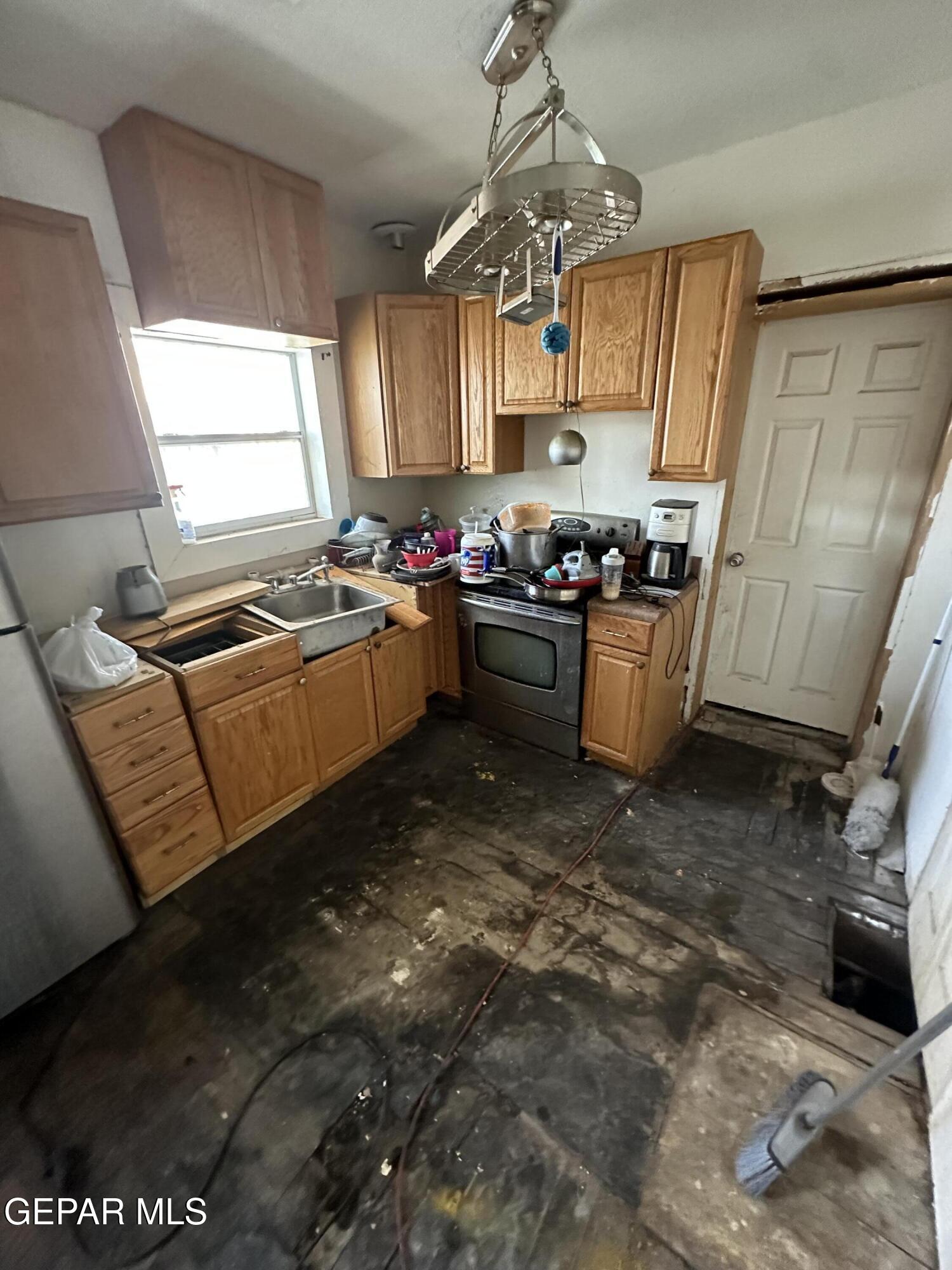114 Fern Way El Paso, TX 79902 - Photo 8 of 9 a kitchen with sink a stove and refrigerator