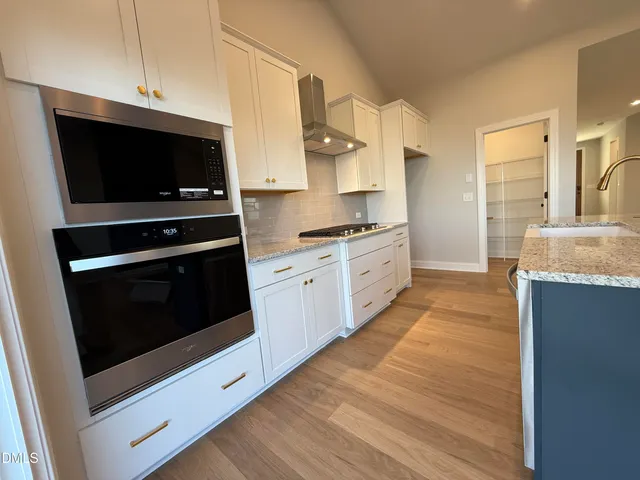 a kitchen with stainless steel appliances kitchen island granite countertop a stove a sink and a microwave