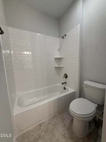 a white toilet and tub sitting next to a bathroom sink