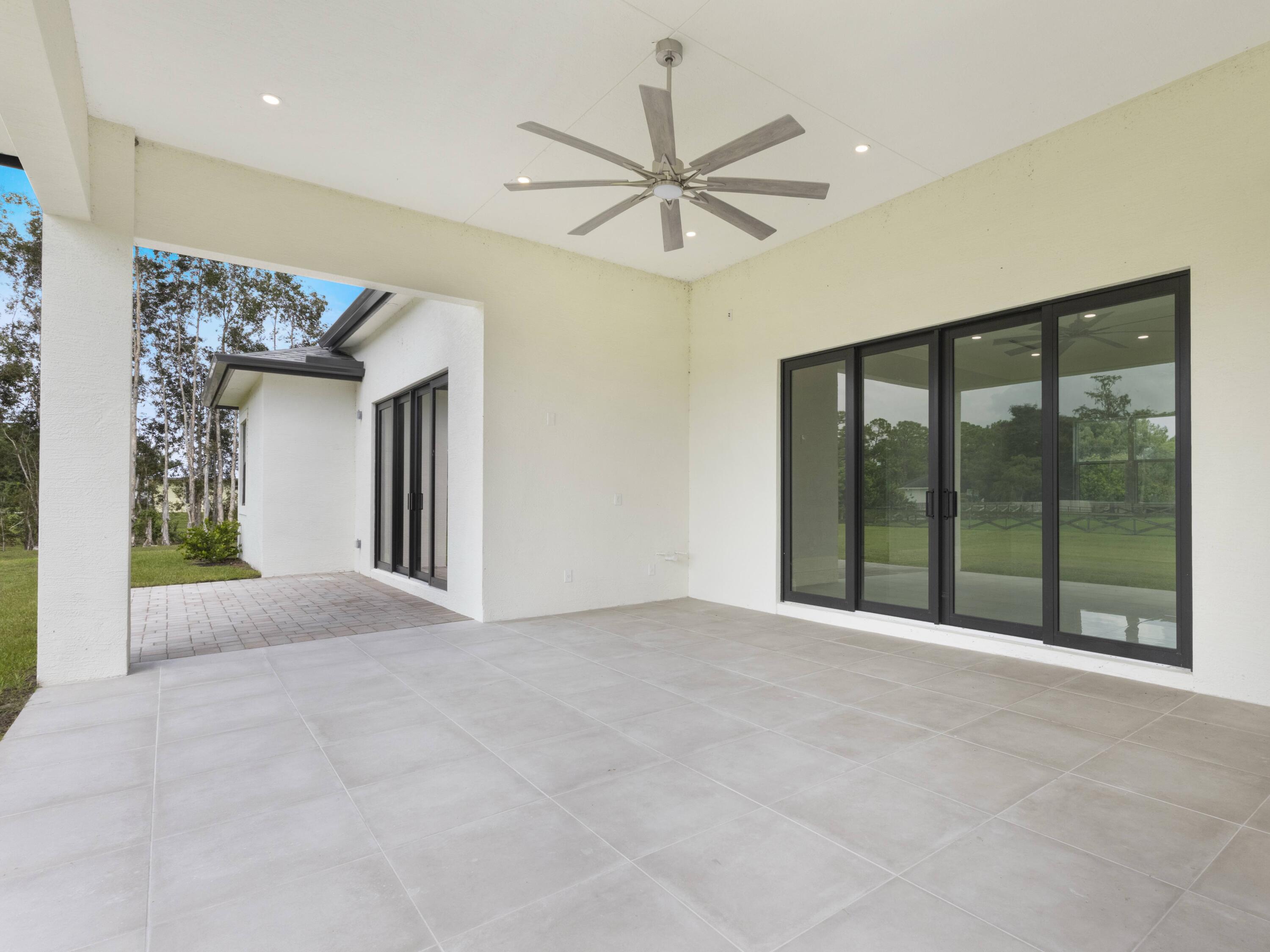 17436 71st Lane North Loxahatchee, FL 33470 - Photo 47 of 50 a view of a hallway with a chandelier fan and windows
