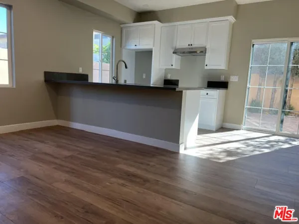 a view of a kitchen with wooden floor and a fireplace