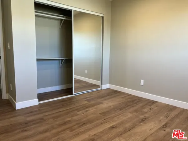 an empty room with wooden floor and closet