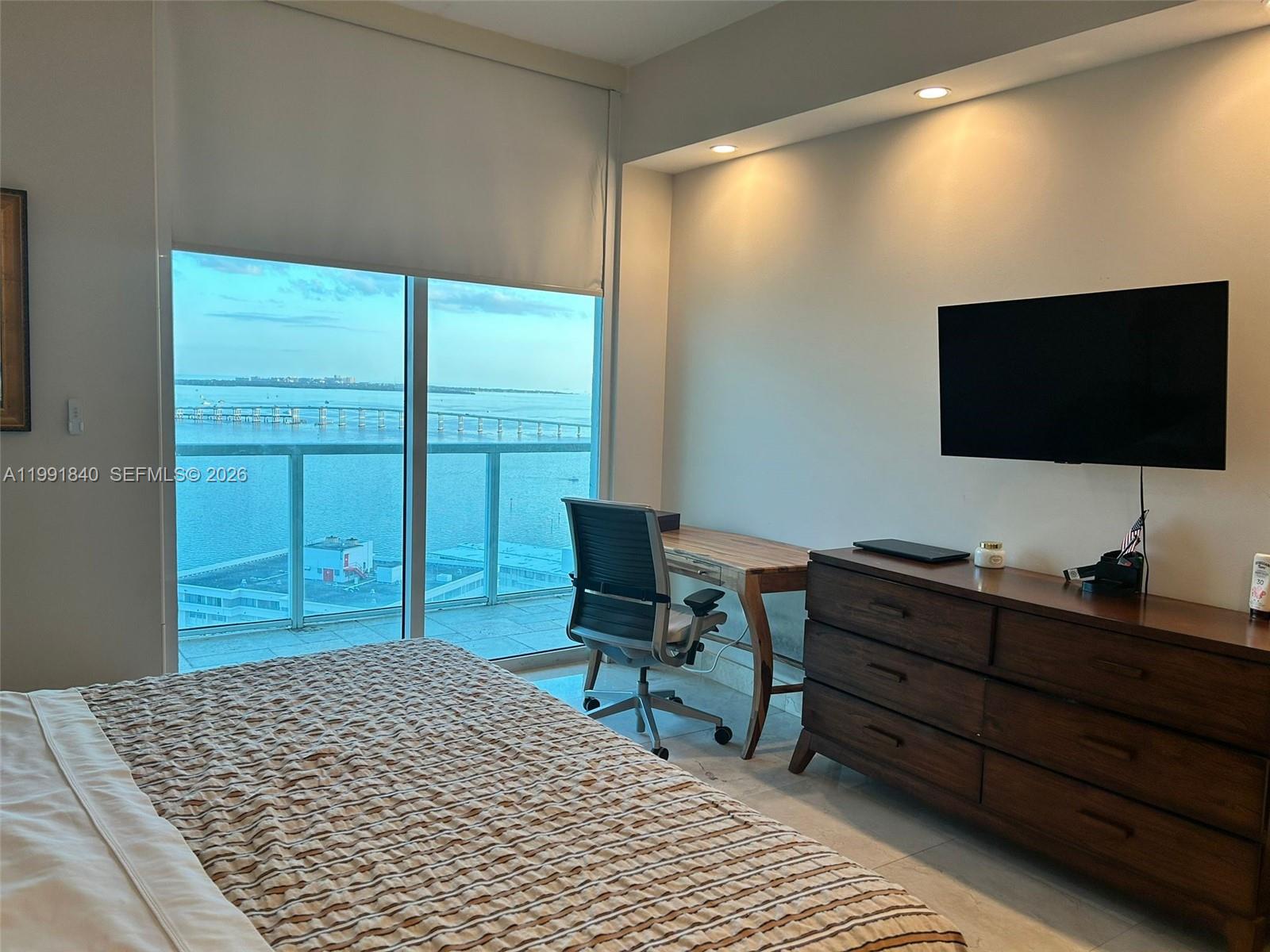 218 Southeast 14th Street, Unit TS303 Miami, FL 33131 - Photo 7 of 16 a bedroom with a bed and a flat screen tv