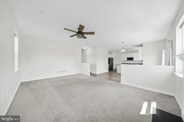 a view of a room with wooden floor and ceiling fan