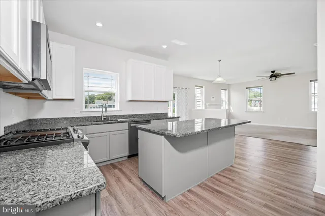 a kitchen with granite countertop cabinets stainless steel appliances and a counter space
