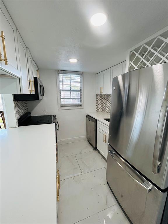 2787 L B McLeod Road, Unit D Orlando, FL 32805 - Photo 2 of 9 a kitchen with stainless steel appliances a refrigerator and a stove