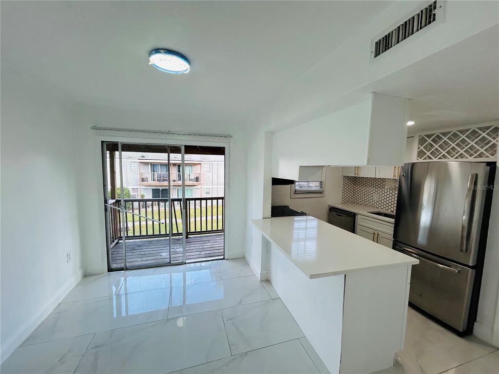 2787 L B McLeod Road, Unit D Orlando, FL 32805 - Photo 3 of 9 a kitchen with stainless steel appliances granite countertop a refrigerator sink and stove