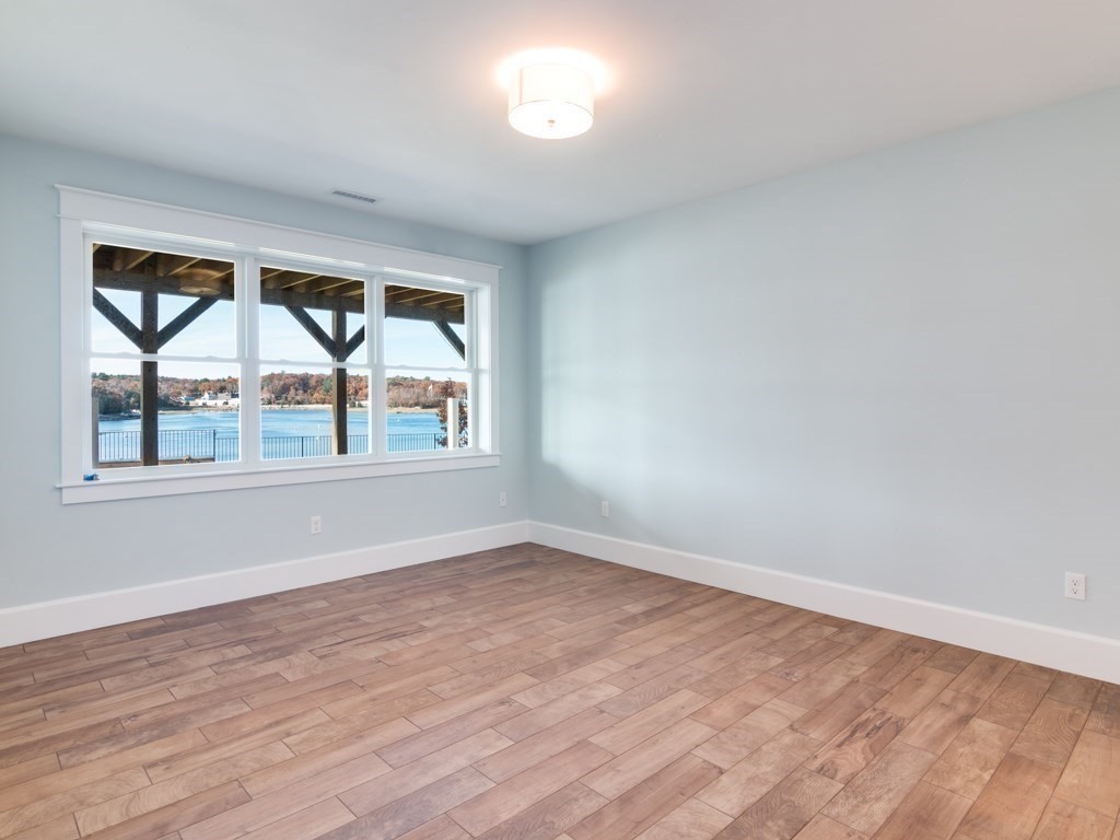 8 Stanwood Point, Unit A Gloucester, MA 01930 - Photo 15 of 21 an empty room with wooden floor and windows