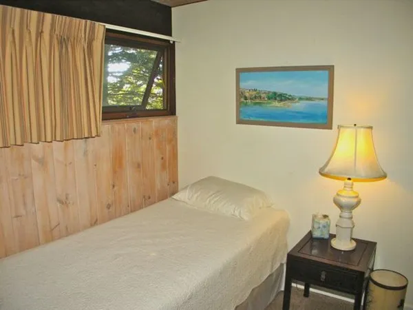 a bedroom with a bed and a lamp on table