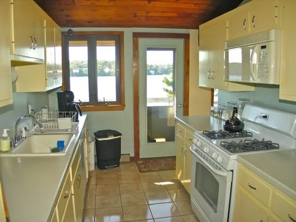 a bathroom with a granite countertop sink a toilet a mirror and bathtub
