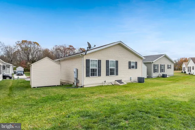 a front view of house with yard and trees in the background