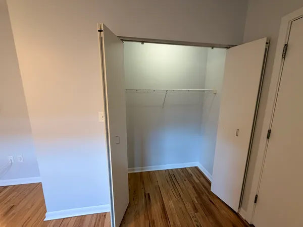 a view of walk in closet with wooden floor
