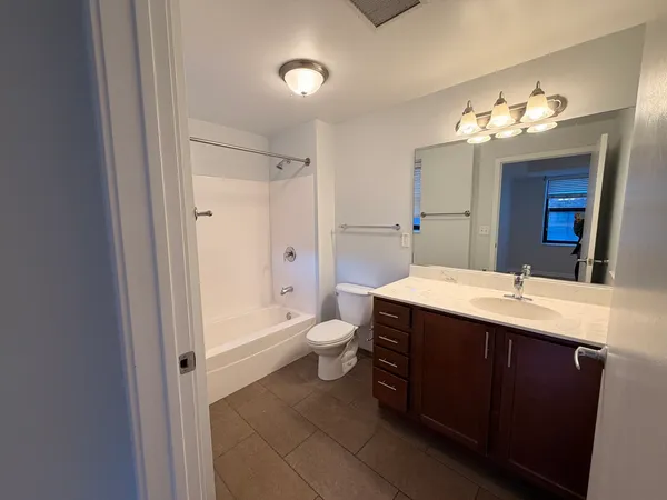a bathroom with a double vanity sink toilet and a mirror